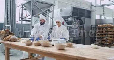 在一家商业烘焙厂工作，两个面包师非常有魅力，他们制作面团来烘焙面包